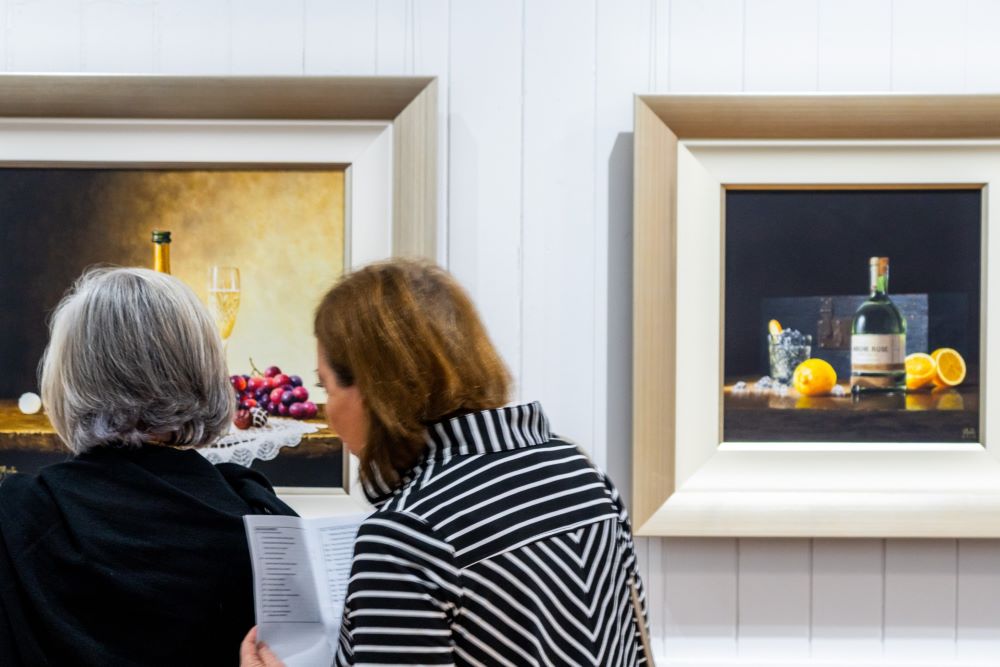 Two women looking at still life artwork